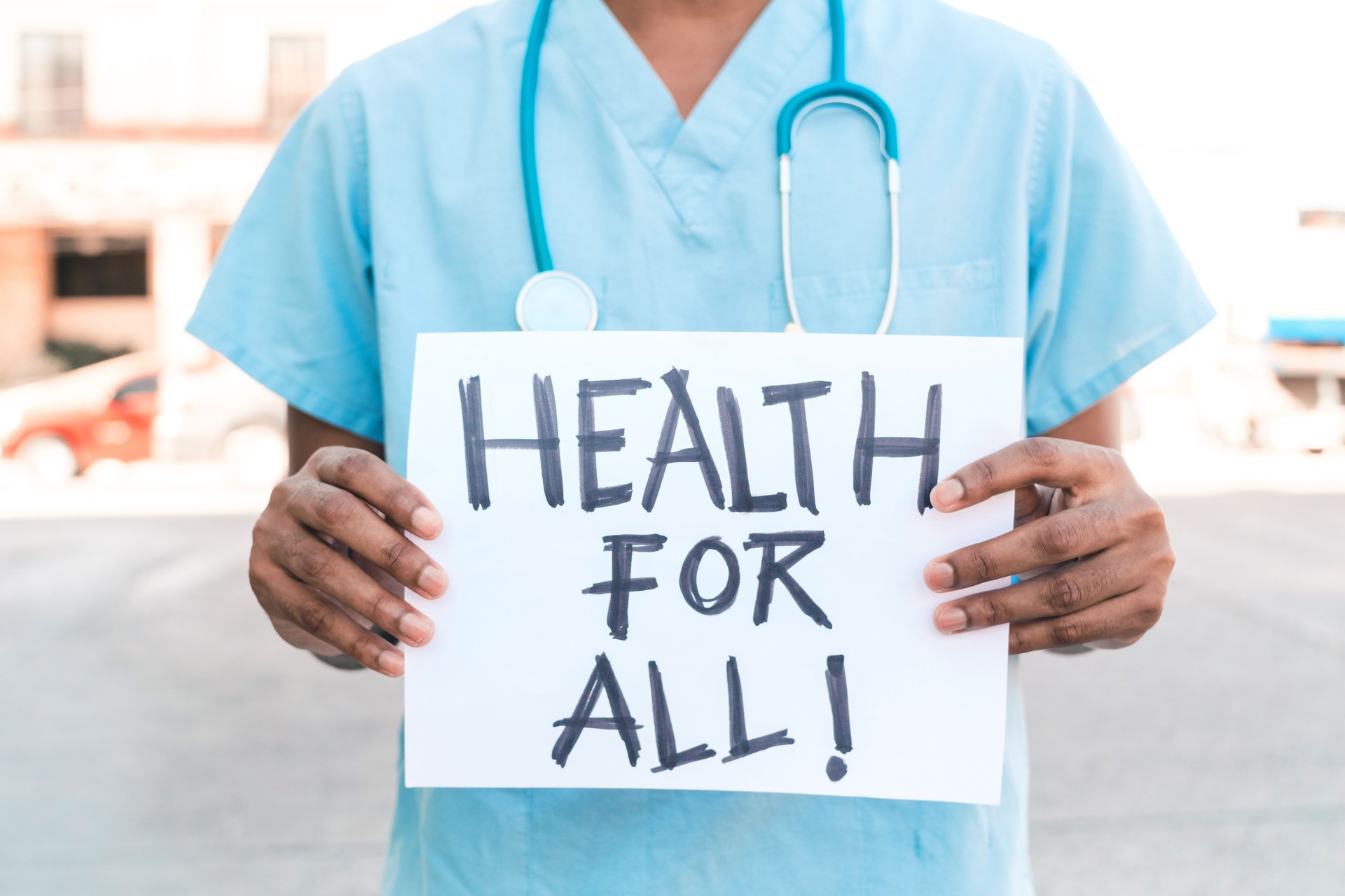 portrait of an unrecognizable African American man holding a banner that says "health for all" health crisis concept.