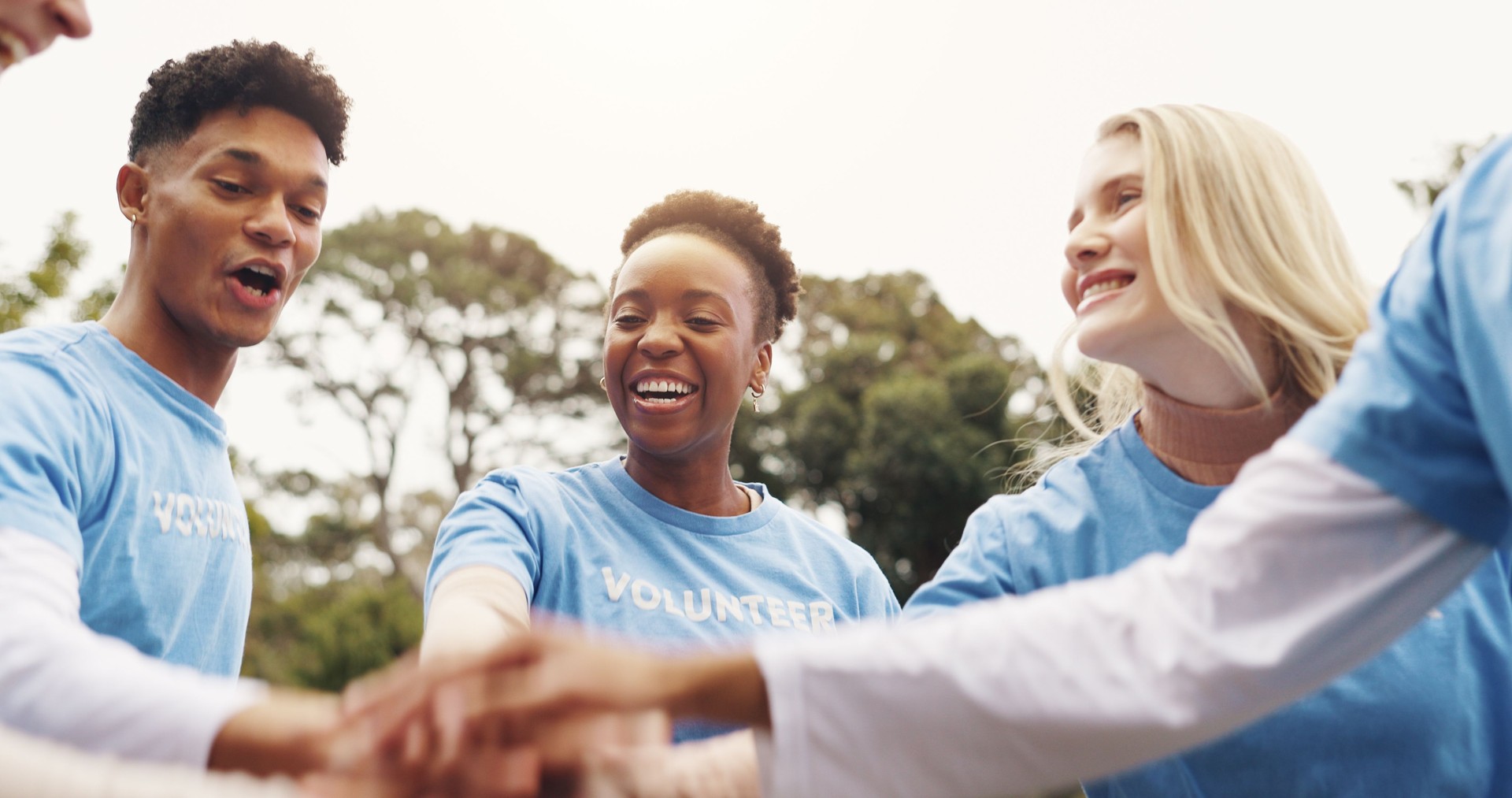 Park, volunteer and hands of people in circle together for solidarity in sustainable green project. Collaboration, goals and friends in huddle for teamwork, community care and social responsibility